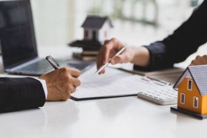 Real Estate Agent Holding Pen Pointing At Contract Document For